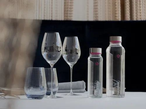 Elegante Tischdekoration mit zwei Diamond-Glaswasserflaschen und Weingläsern