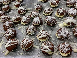 Homemade chocolate sandwich cookies with cream filling and white icing drizzle