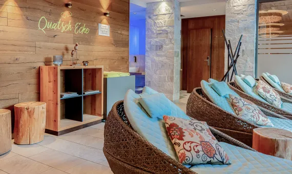 Moderne Wellness-Lounge mit geflochtenen Liegen und stimmungsvoller Beleuchtung