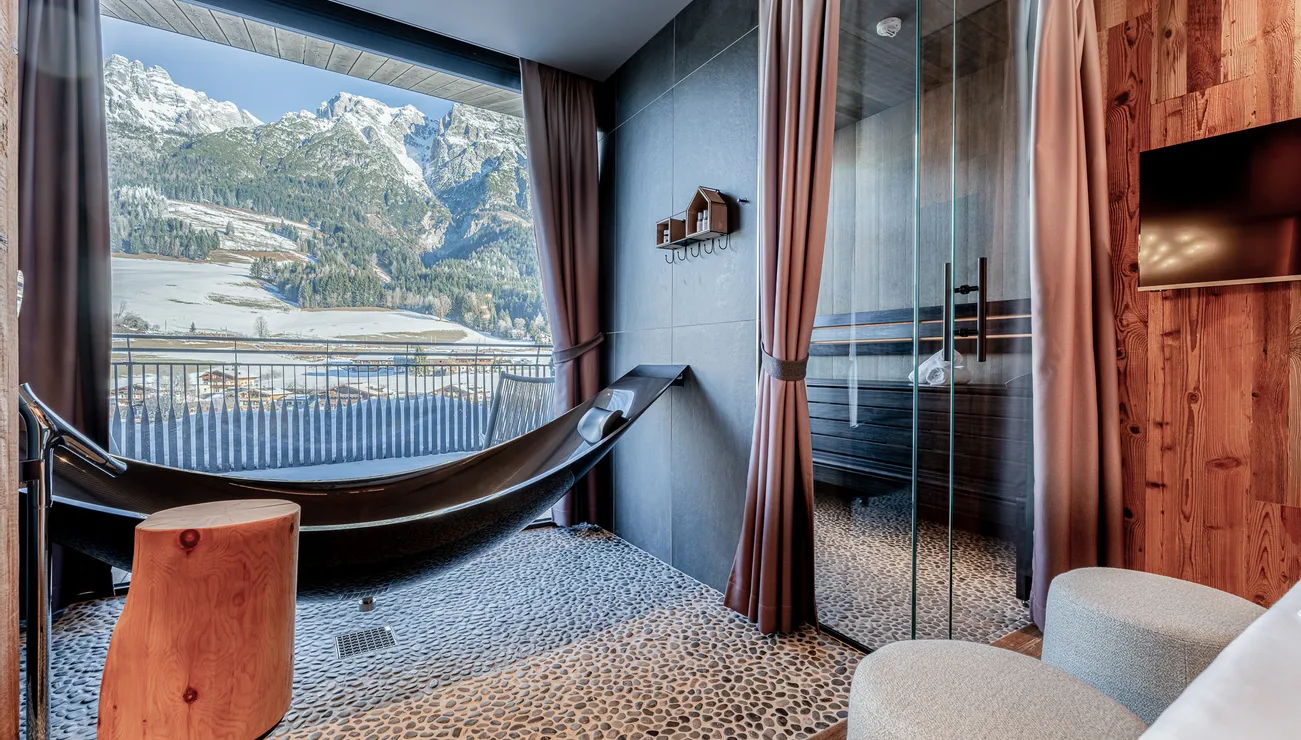 Luxury hotel room with hammock bathtub, sauna and mountain view