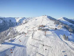 Sunny alpine ski resort with chairlifts, snow-covered slopes and mountain lodges