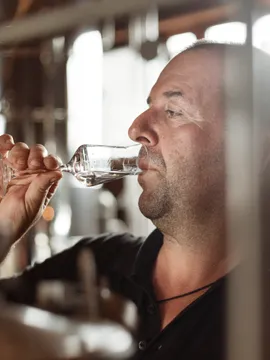 Mann verkostet Schnaps