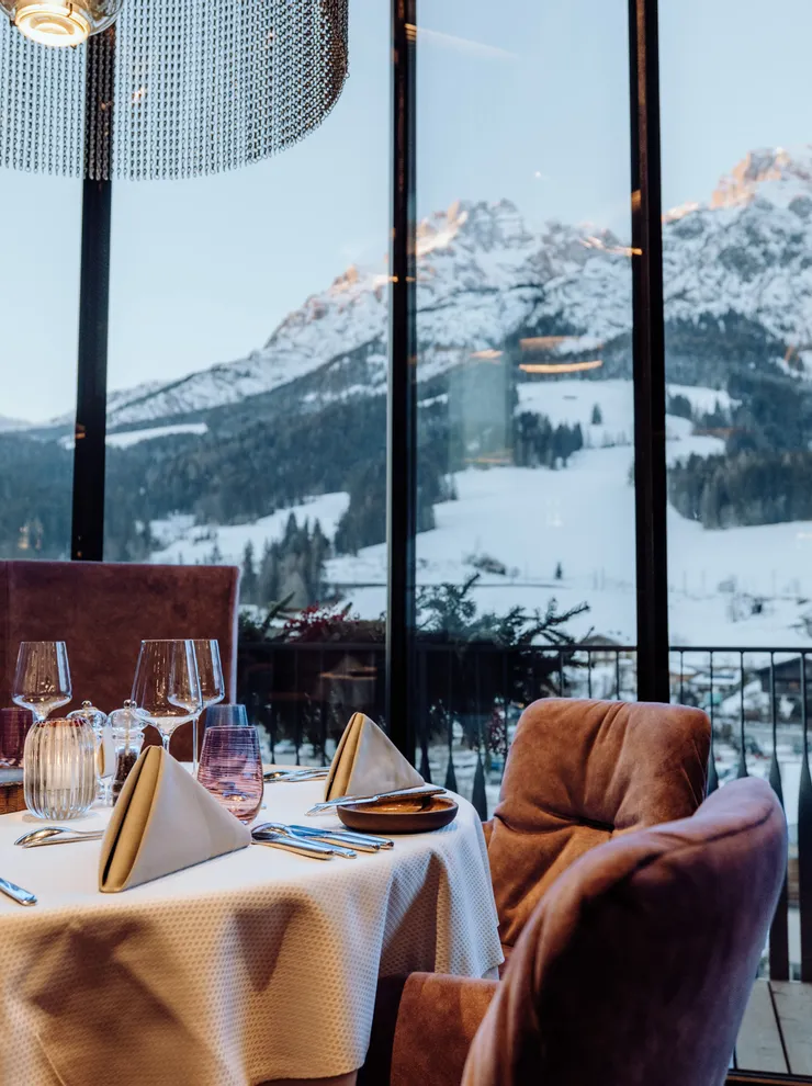 Elegant restaurant table set with mountain view through large panoramic windows