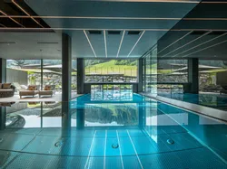 Luxuriöser Innenpool mit Liegestühlen und Panoramablick auf die Berge