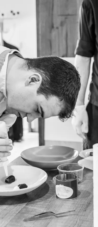 Koch richtet vorsichtig ein Gourmetgericht in einer Profiküche an