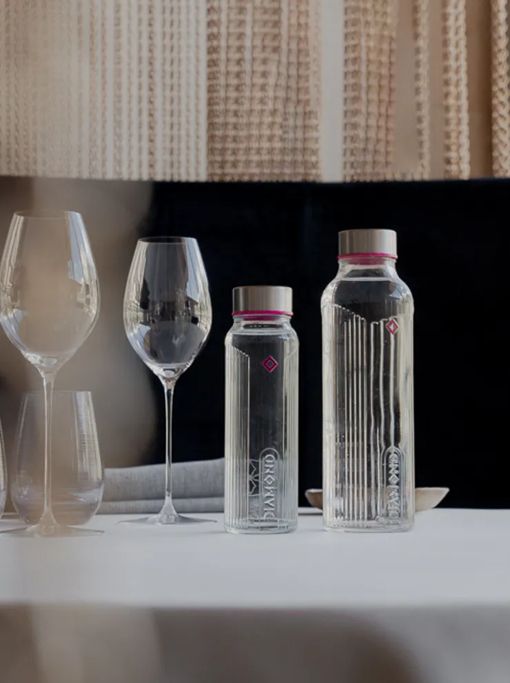 Elegante Tischdekoration mit Glaswasserflaschen und Weingläsern in gehobenem Restaurant