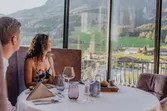 Couple dining in a scenic mountain view restaurant with elegant table setting