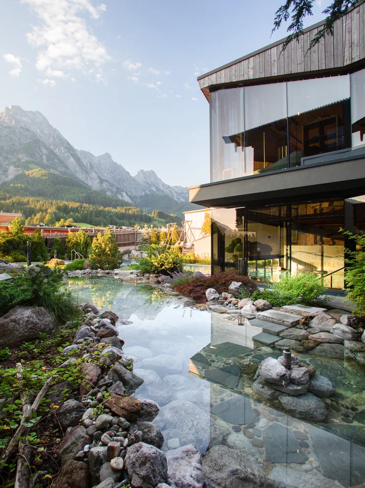 Modernes Spa-Resort mit Kneippteich und Bergblick in alpiner Landschaft