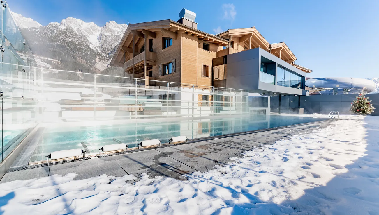 Luxuriöses Alpenhotel mit beheiztem Außenpool und schneebedecktem Boden