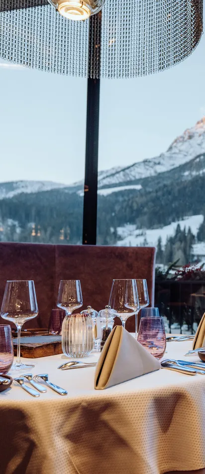 Elegant restaurant table set with mountain view through large glass windows