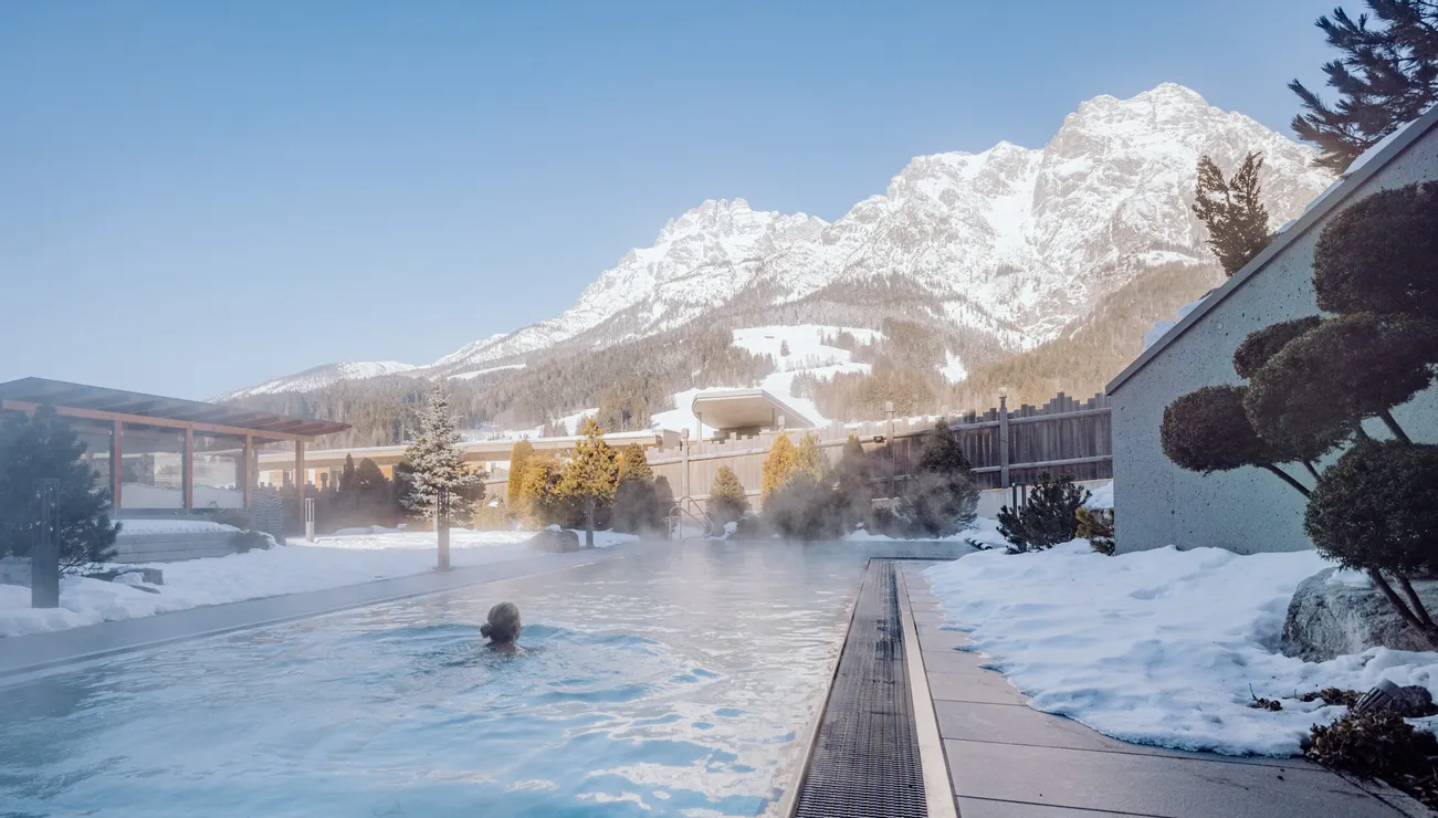 Thermal-Außenpool mit Bergblick und schneebedeckter Umgebung im Winterresort