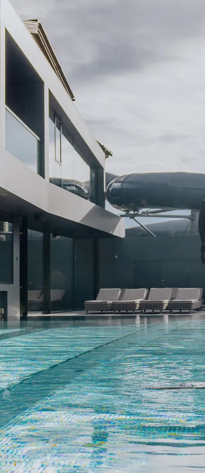 Couple relaxing at outdoor hotel pool with modern spa and water slide