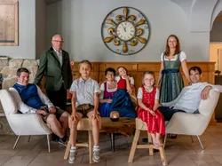 Familie in traditioneller bayerischer Kleidung im gemütlichen Wohnzimmer