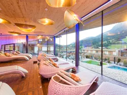 Luxuriöser Spa-Ruheraum mit Panoramablick auf Berge und modernen Rattanliegen