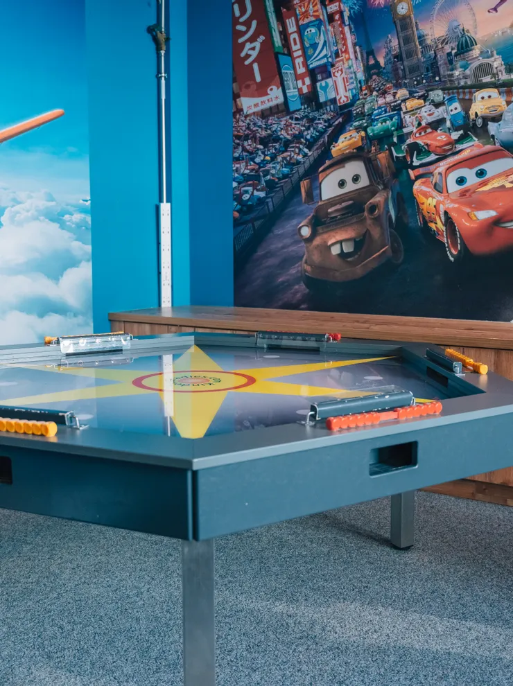 Children’s playroom with Cars and Planes movie murals and interactive game table