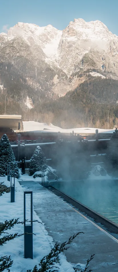 Außen-Thermalbecken in verschneitem Alpenresort mit Bergblick