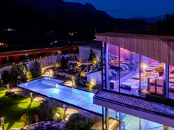 Luxuriöses Spa-Hotel mit Außenpool und beleuchtetem Ruhebereich bei Nacht