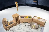 Gourmet appetizers served in wooden toy train on Alpine regional map