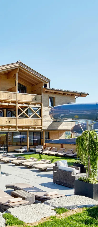 Luxuriöses Alpenresort mit Außenpool, Sonnenliegen und großer Wasserrutsche