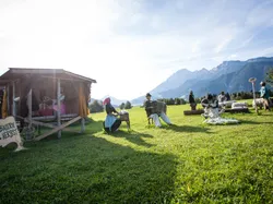 Straw figures at country autumn festival on a meadow with Alpine mountain backdrop