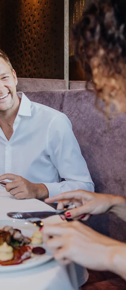Couple enjoying a fine dining experience with wine in a stylish restaurant