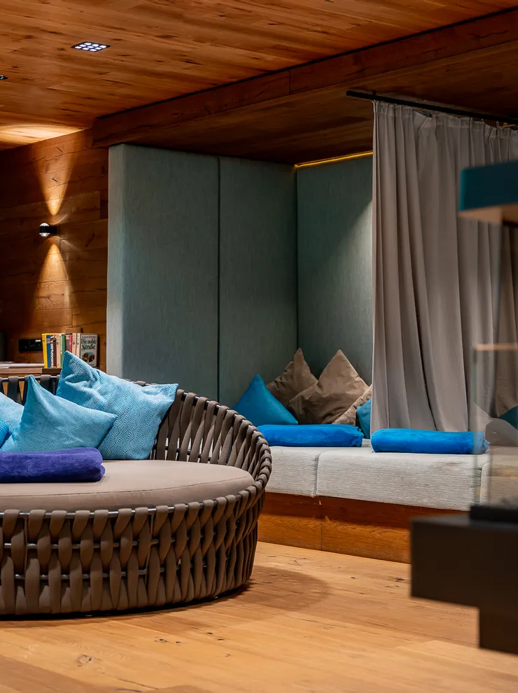 Cozy spa lounge with round loungers, blue cushions, and a modern fireplace