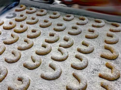 Frisch gebackene Vanillekipferl mit Puderzucker bestäubt