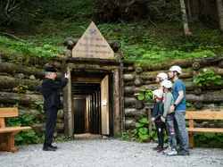 Family wearing helmets stands at the entrance of the historic Barbarastollen mine with guide