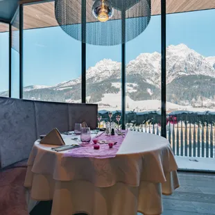 Elegant set restaurant table with a view of snow-covered alpine mountains