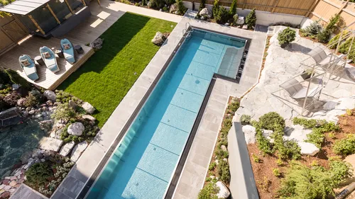 Moderner Garten mit rechteckigem Pool, Liegefläche und bepflanztem Gartenbereich