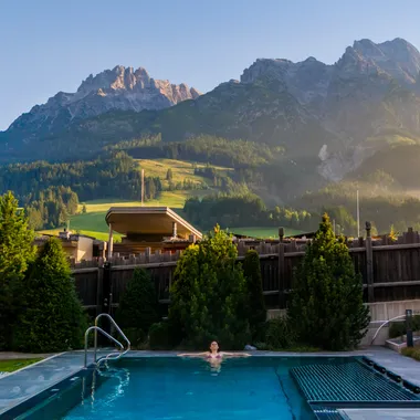 Frau entspannt im Thermalpool, die Steinberge im Hintergrund