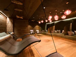 Modern spa relaxation room with hanging lounge chairs and warm ambient lighting