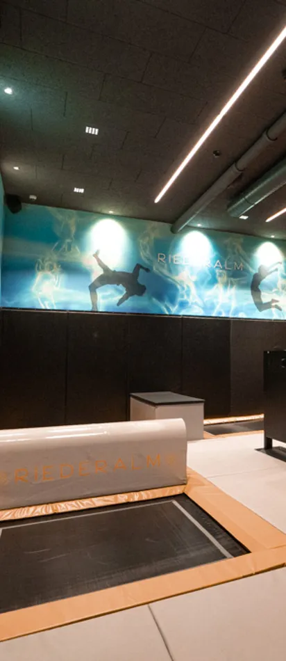 Indoor-Trampolin-Parkour mit gepolstertem Boden und Wandgrafiken in der Riederalm