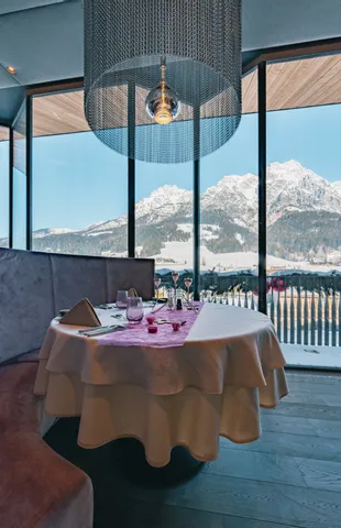 Elegant gedeckter Restauranttisch mit Blick auf schneebedeckte Alpen