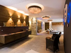 Modern wellness spa lounge with wicker chairs, recliners, and ambient lighting