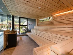 Modern indoor wooden sauna with benches and panoramic mountain view