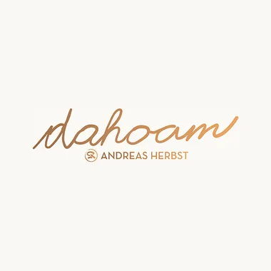 Logo mit handschriftlichem Schriftzug dahoam und Andreas Herbst in Orange