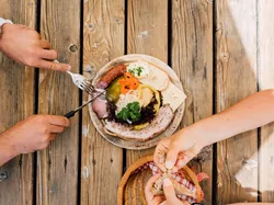 Rustic cold cuts platter with cheese, ham, pickles and bread on wooden table