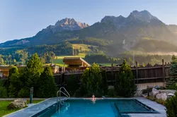 Frau entspannt im Thermalpool, die Steinberge im Hintergrund