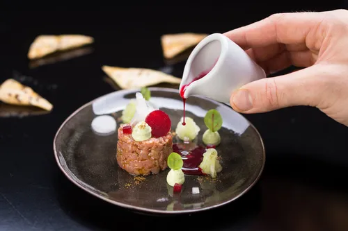 Gourmet-Rindertatar mit Rote-Bete-Sauce auf elegantem schwarzen Teller