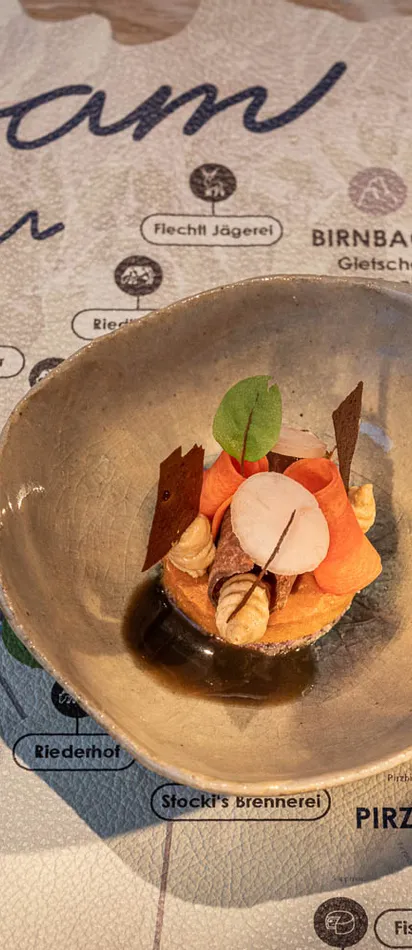 Gourmetvorspeise in Keramikschale auf einer Leogang-Karte präsentiert