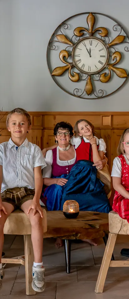 Family in traditional Bavarian clothing sitting and standing in cozy living room