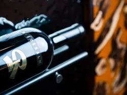 Riederalm wine bottle resting in a metal wine rack