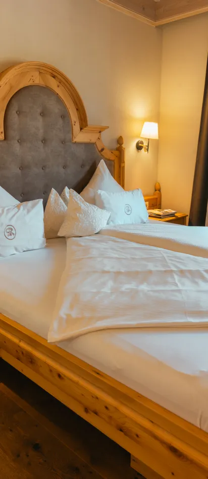 Cozy hotel room with double bed, wooden furniture and warm lighting