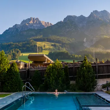  Frau entspannt im Thermalpool, die Steinberge im Hintergrund