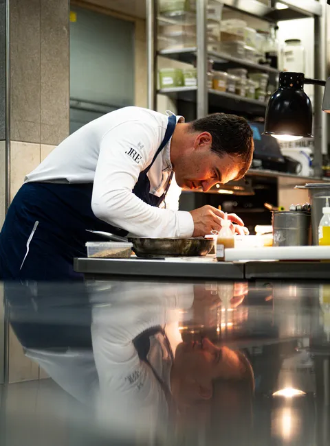 Koch richtet Gourmetgericht präzise in einer Profiküche an