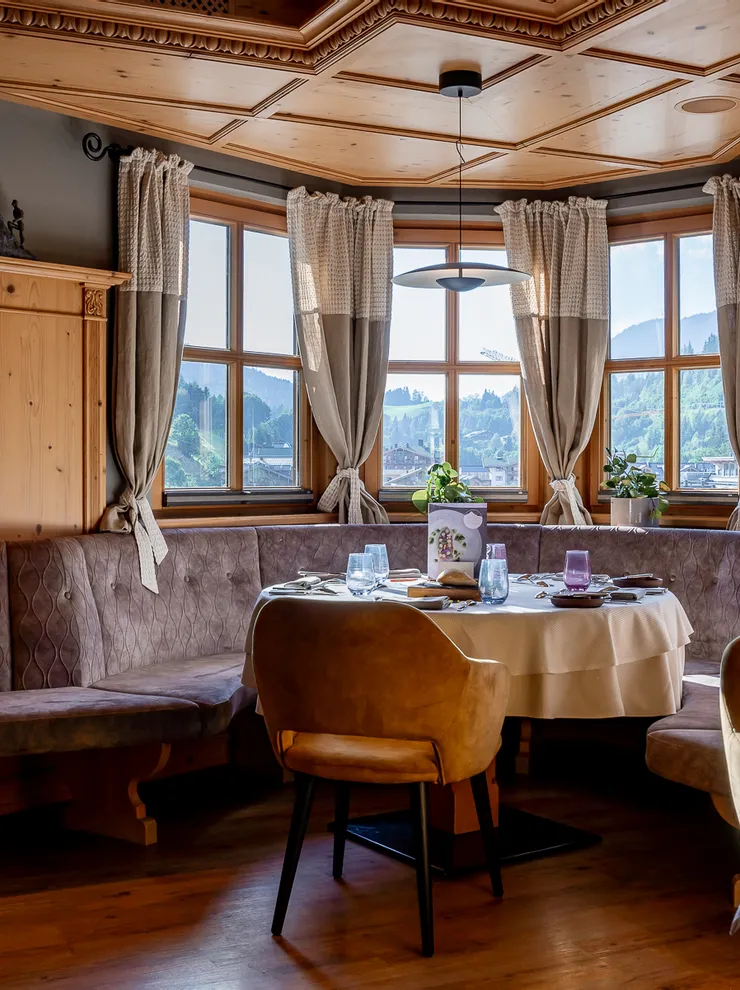 Gemütliche Sitzecke im Restaurant mit Holzdekor und Panoramablick auf die Berge