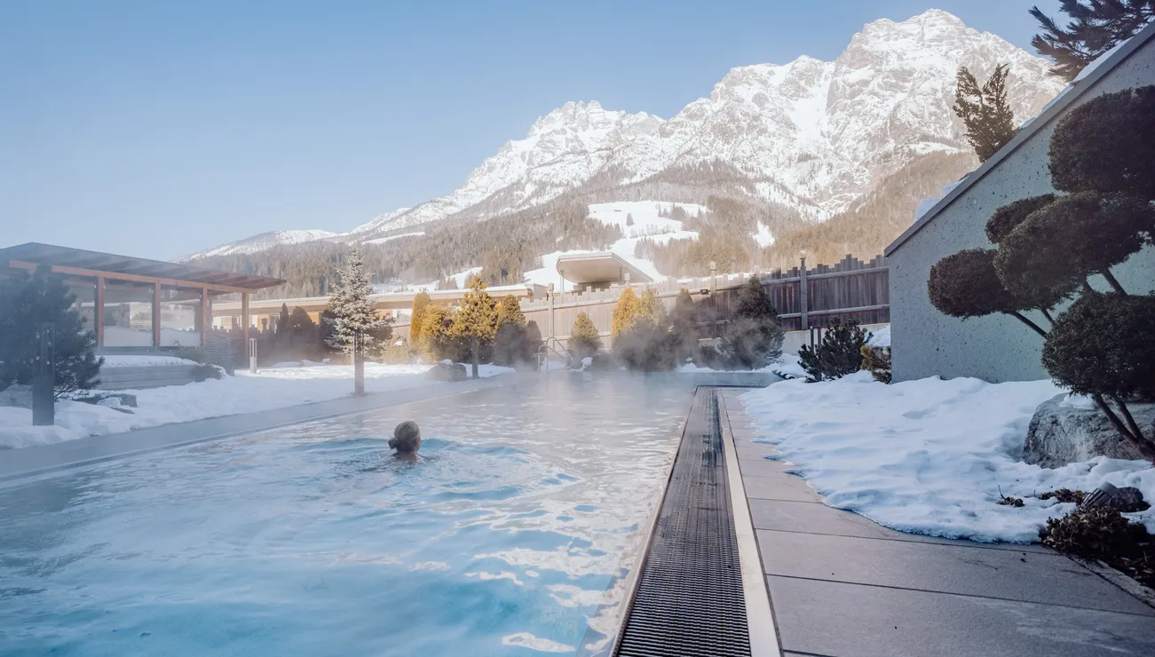 Thermal-Außenpool mit Bergblick und schneebedeckter Umgebung im Winterresort