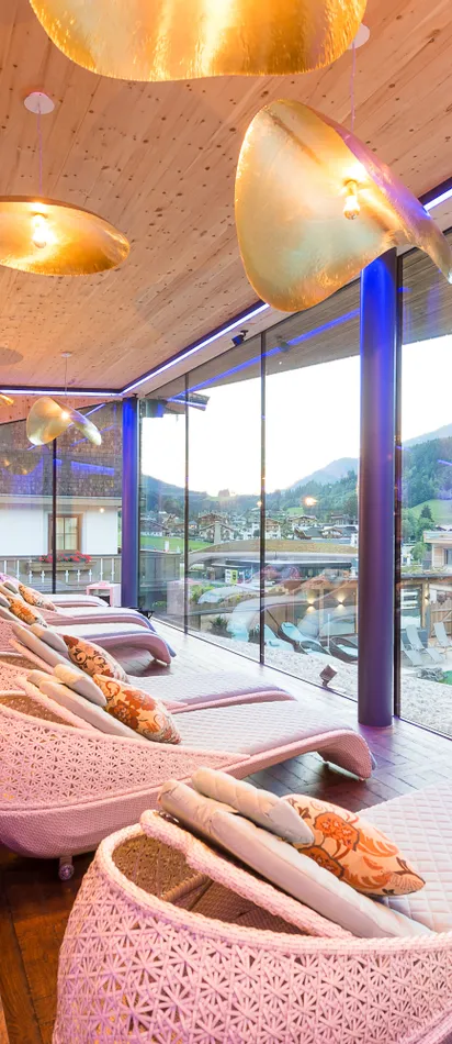 Luxury spa relaxation lounge with panoramic mountain view and modern wicker loungers