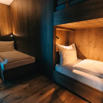 Modern bedroom with single bed and illuminated wooden bunk bed